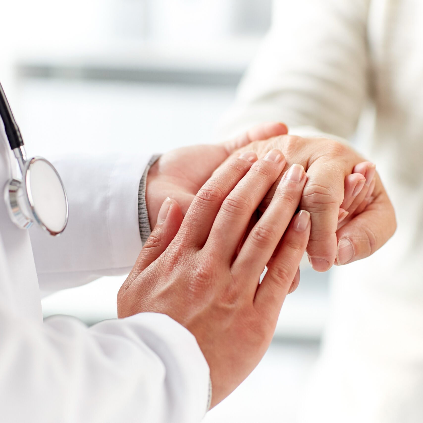close up of doctor holding old man hand